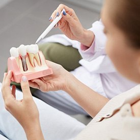 a patient holding a mode of a dental implant