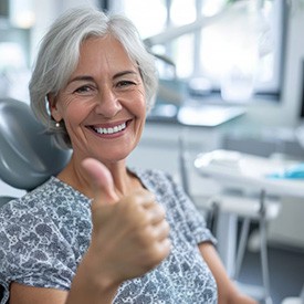 a dental patient giving a thumbs-up